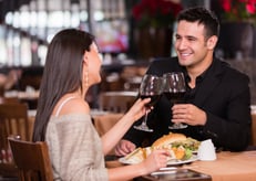 Couple having dinner at a restaurant and making a toast
